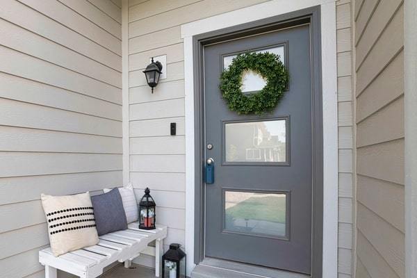Modern gray door and porch on home with vinyl siding
